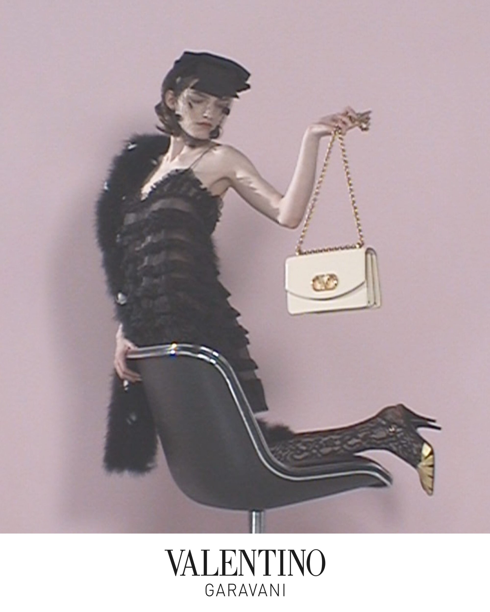Model in black ruffle dress holding a white handbag while leaning over a chair against a pink backdrop