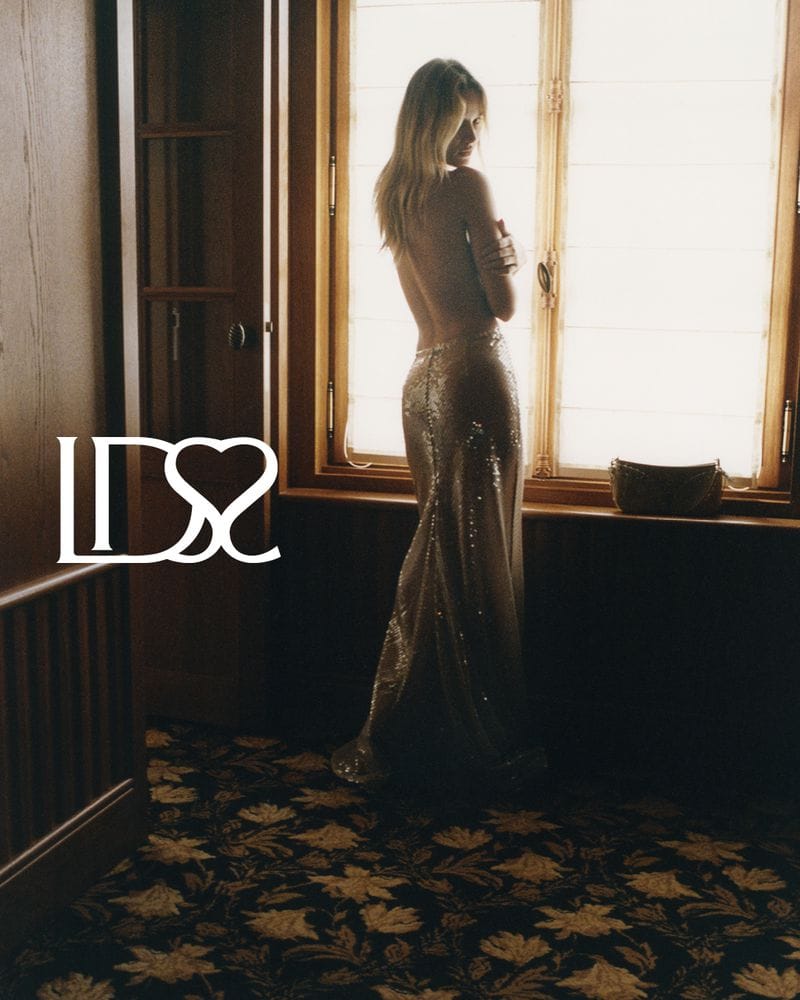 Model Paige Reifler in a sequined gown standing by a window for Ludovic de Saint Sernin Spring 2025 ad campaign.