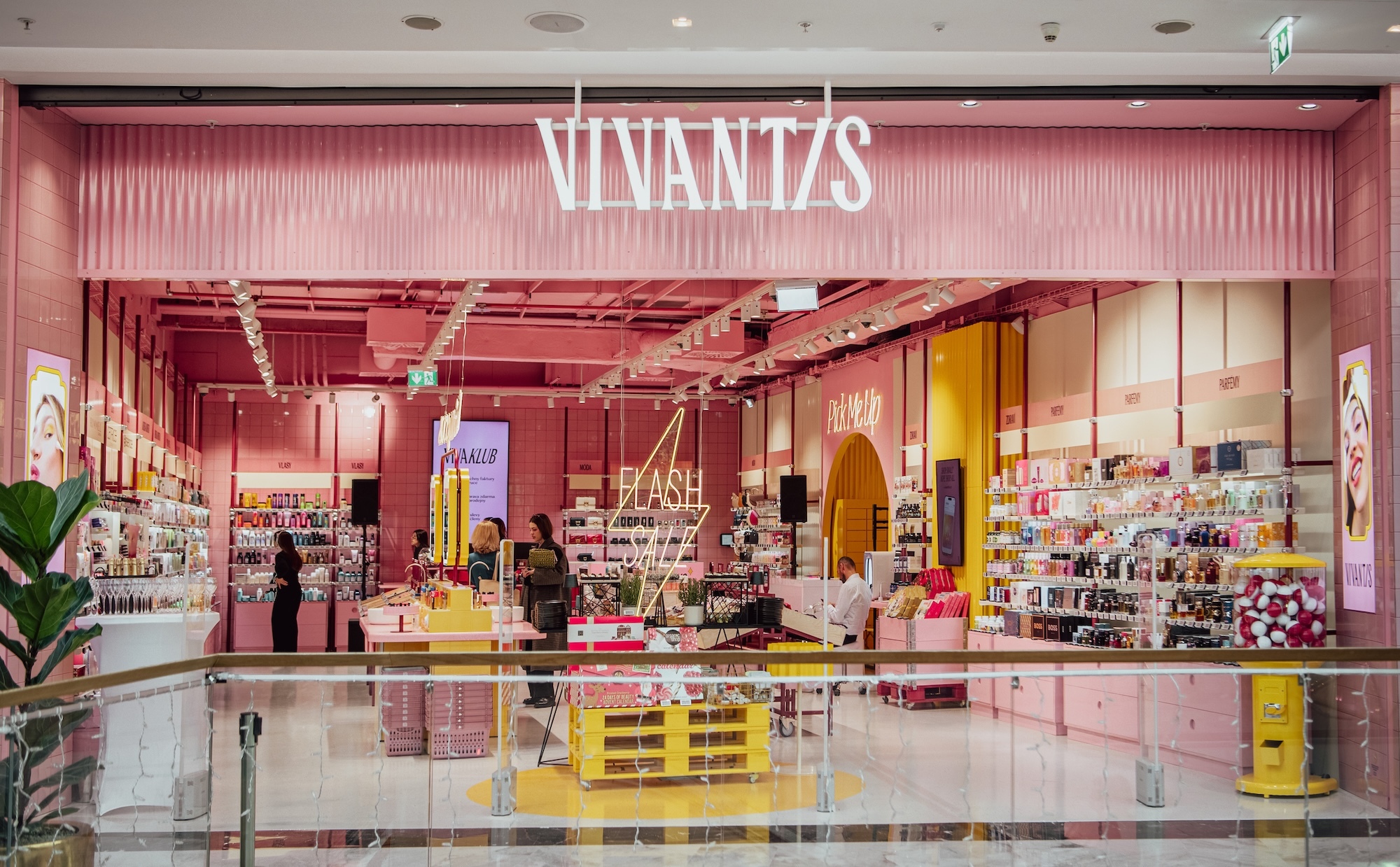 Storefront exterior view of Vivantis showcasing a vibrant pink interior retail design with shelves and displays