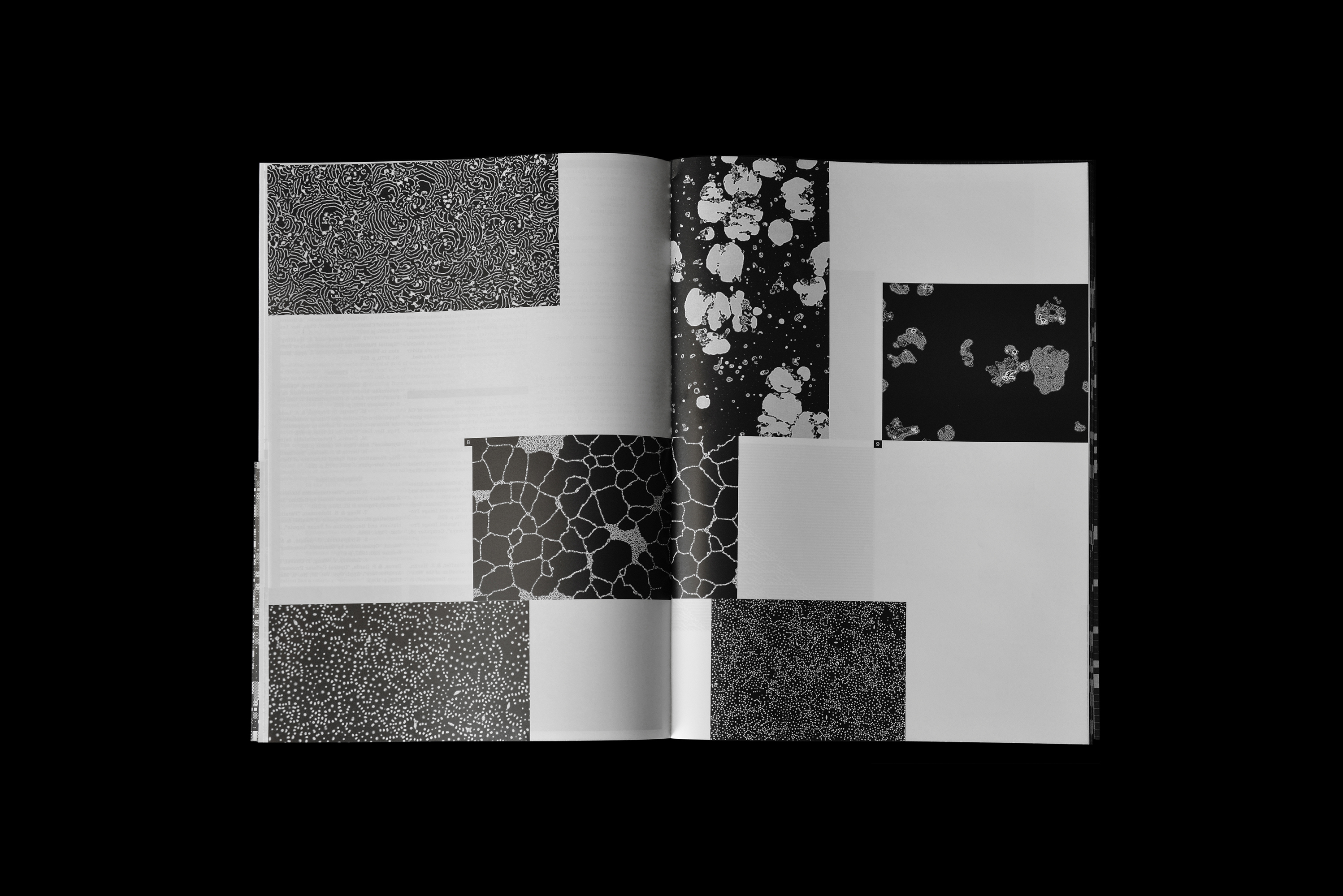 Open book spread showing black and white graphic patterns and geometric layouts on white pages against a dark ground.