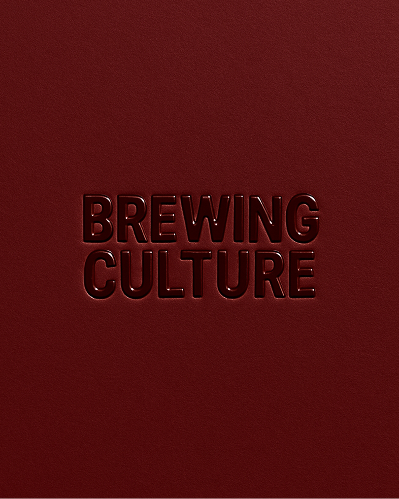 Embossed dark red typography reading Brewing Culture centered on a dark textured paper background.