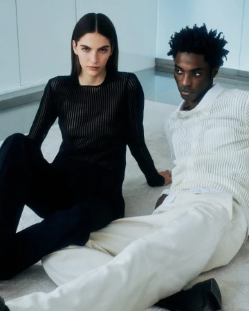 Two models seated on a light textured floor wearing Helmut Lang apparel for the pre-Fall 2024 campaign, photographed by Daniel Shea.