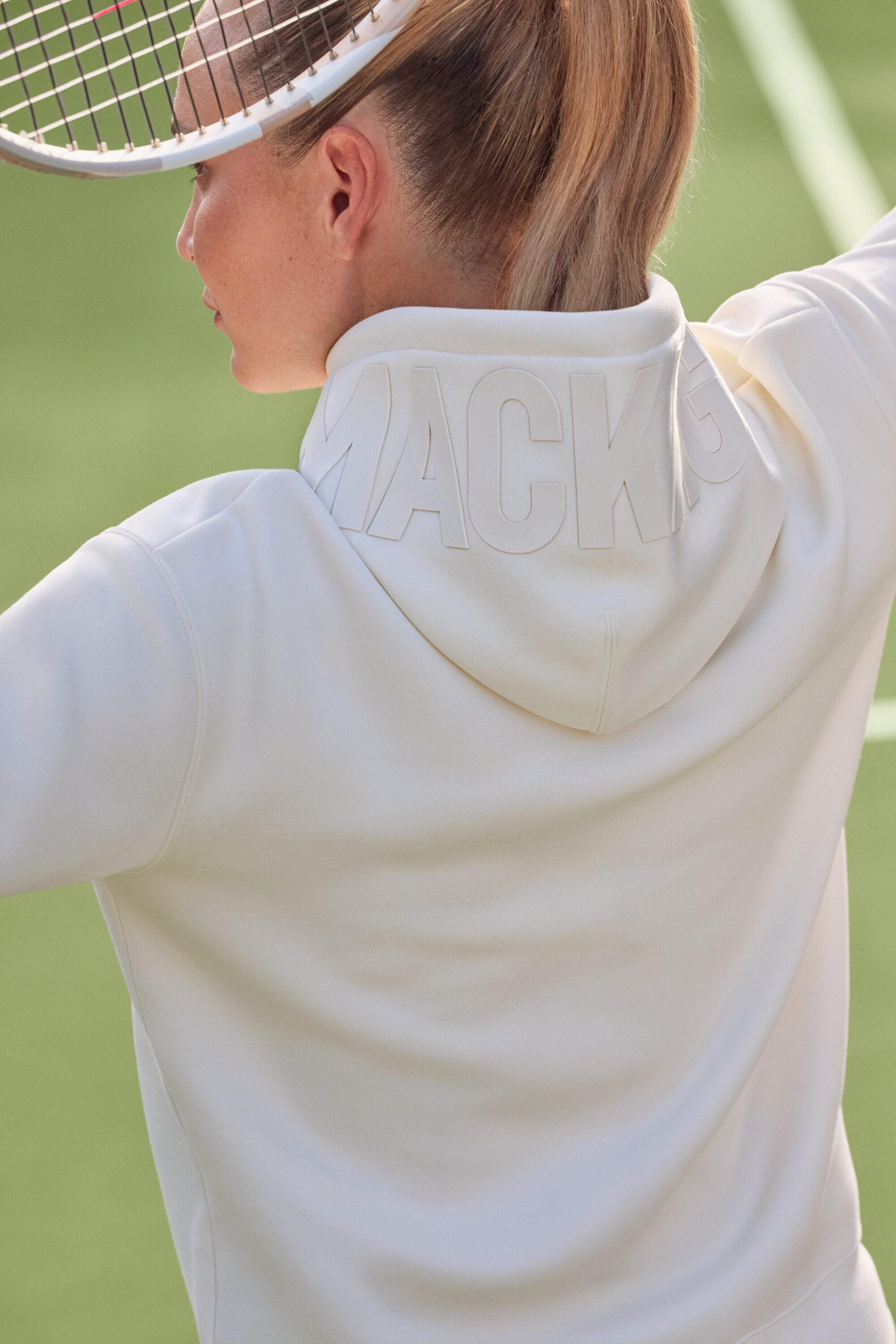 Model wearing a white hoodie holding a tennis racket on a court for Mackage Protect Your Craft campaign