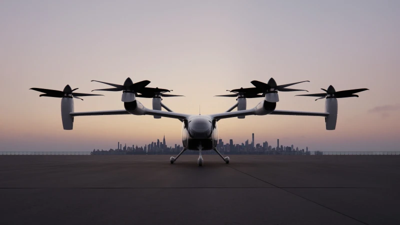 Joby Aviation electric aircraft parked on tarmac facing forward with distant city skyline under sunset sky
