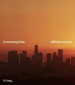 City skyline silhouetted against a warm orange sunset sky with bold white overlaid text