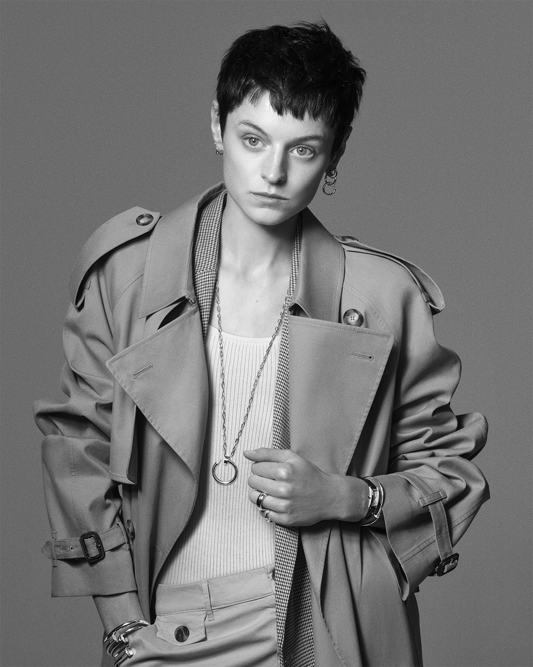 Model Emma Corrin wearing a trench coat and metallic jewellery for Cartier Juste un Clou campaign.