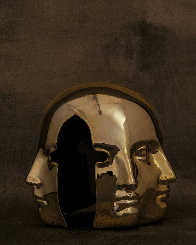 Abstract art featuring a metallic sculpture of three conjoined human faces against a textured backdrop with dark, moody lighting.