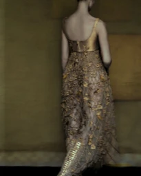 Rear view of a model in a gold textured gown against a dark golden-brown wall for Acne Paper
