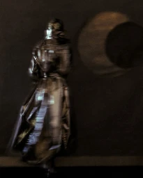Model in a metallic coat shot with motion blur against a dark background with a circular glowing projection