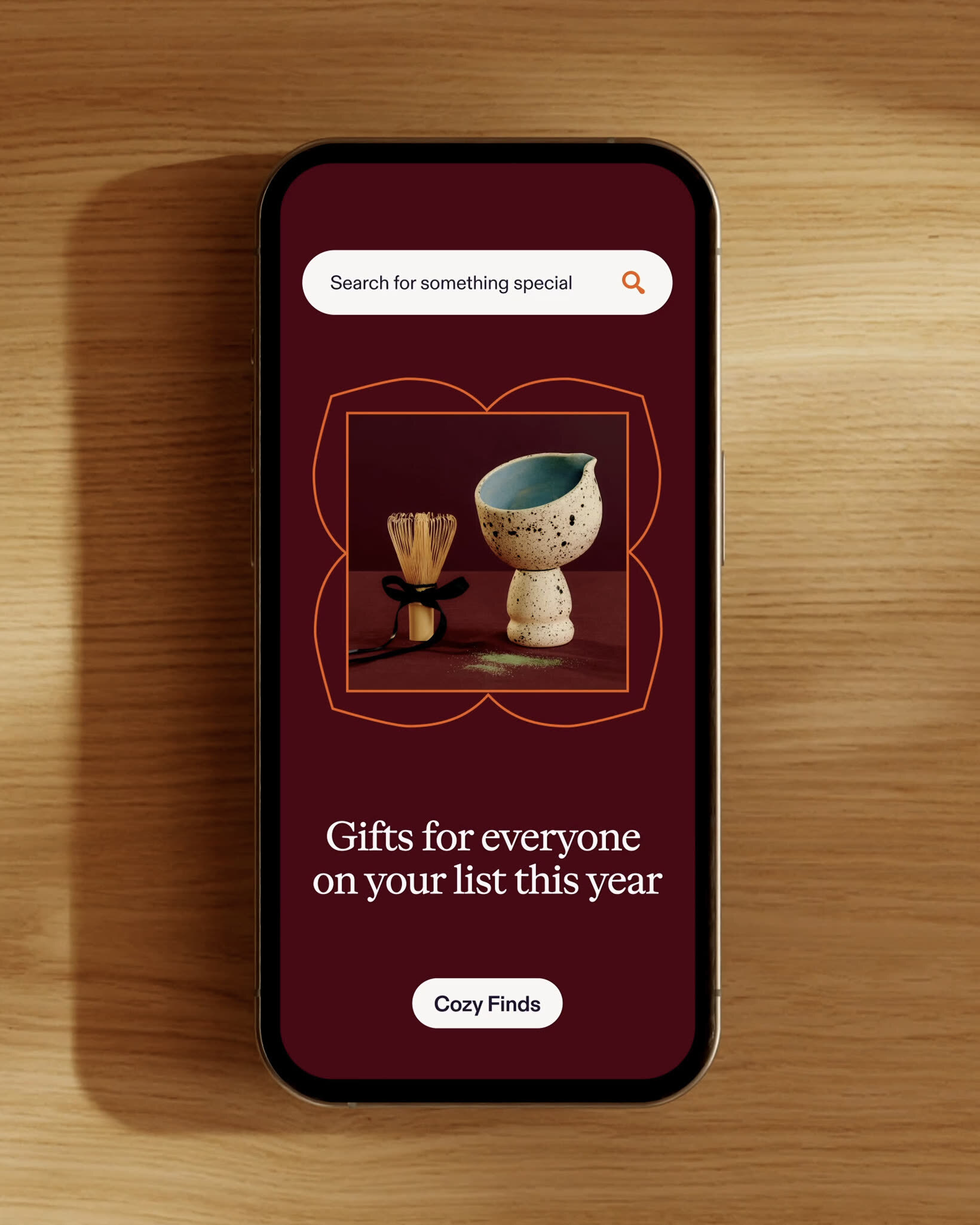 Smartphone displaying Etsy mobile app interface resting on a light wooden surface with a soft shadow cast alongside it.