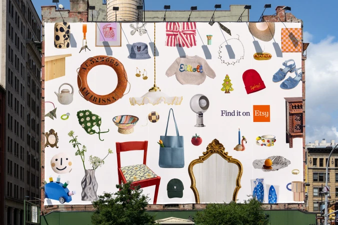 Large outdoor billboard showing a collage of diverse retail products arranged on a white background with the text Find it on Etsy
