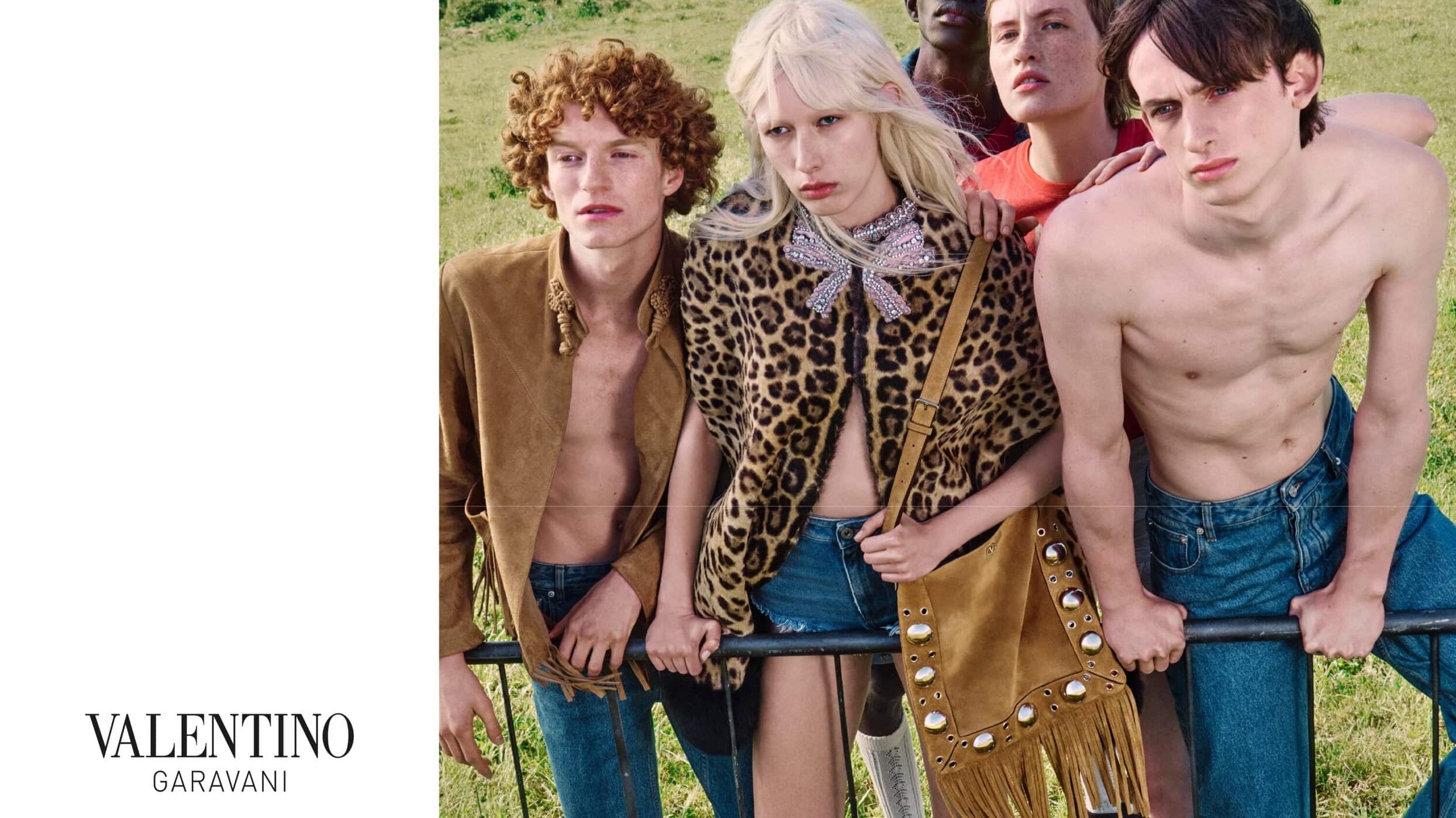 Group of models posing outdoors behind a metal fence for the Valentino Nellcôte Bag ad campaign shot by Julie Greve.