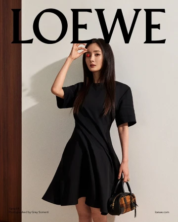Yang Mi wearing a black dress and holding a handbag against a plain wall for Loewe Pre-Fall 2025 ad campaign photographed by Gray Sorrenti