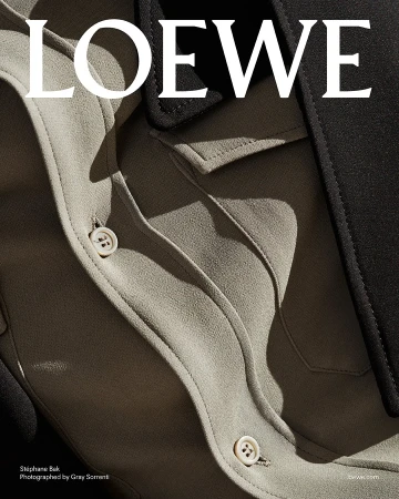 Close-up detail of a beige shirt with white buttons and a black lapel under hard sunlight for Loewe