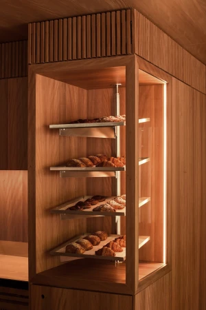 Custom wooden pastry display case with tiered metal shelves holding baked croissants inside Standing Room