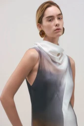 Model wearing an ombre sleeveless dress and large amber earrings against a seamless neutral background