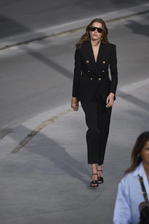 Model in a black double-breasted suit walking on a street for Balmain Pre-Fall 2025 ad campaign