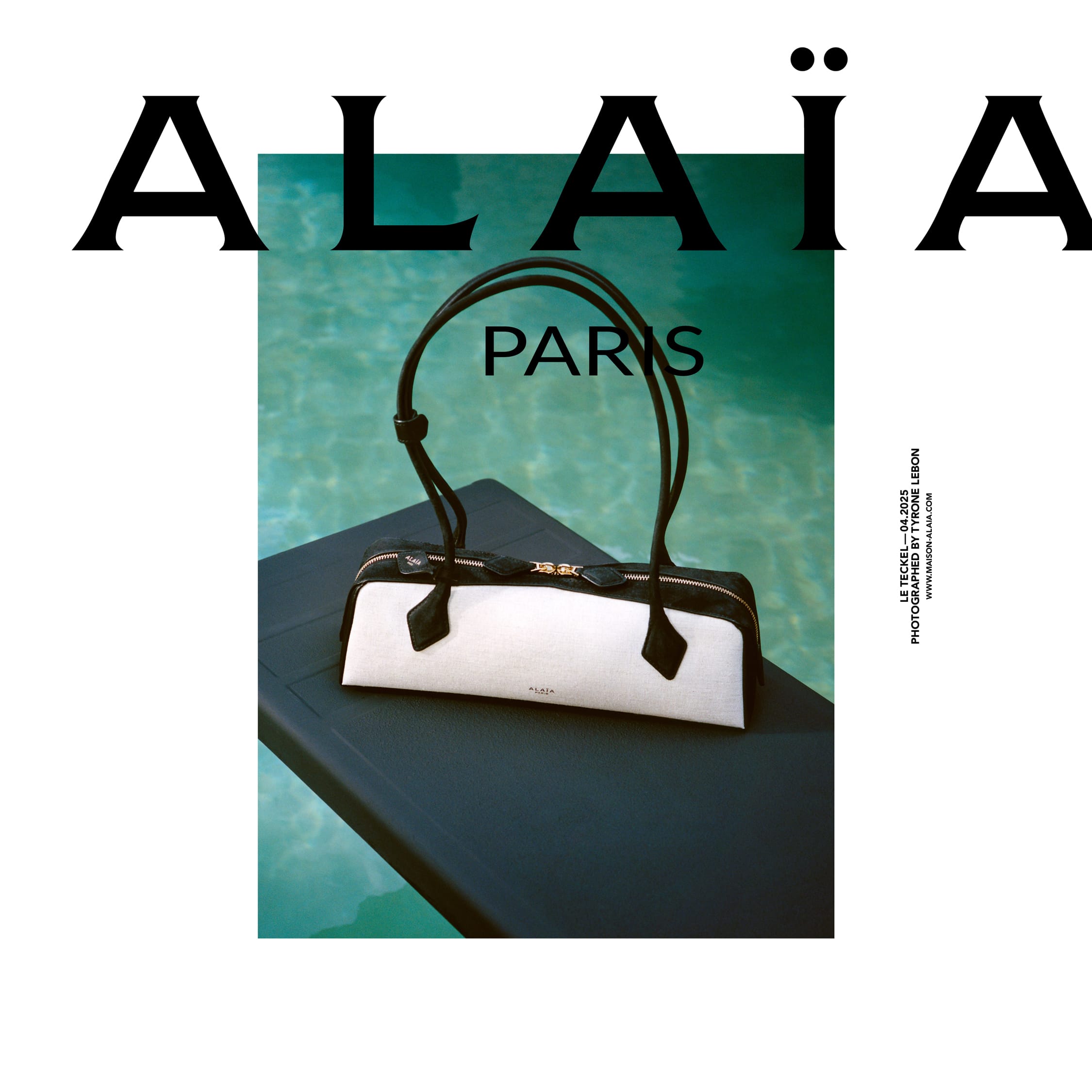 Alaia black and white leather handbag resting on a dark surface beside turquoise pool water