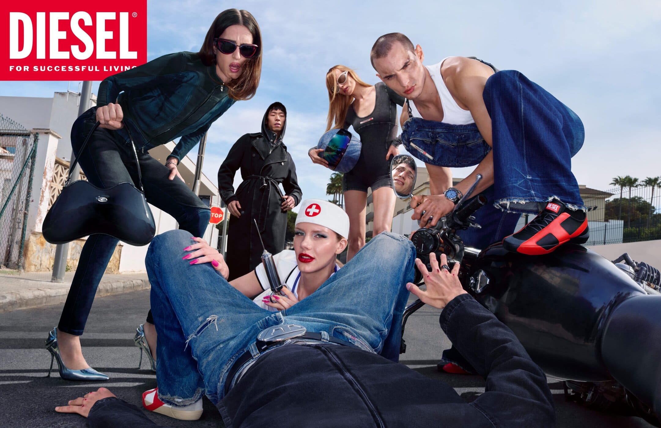 Group of diverse models in dynamic poses on a sunny street for Diesel Fall 2025 denim campaign.