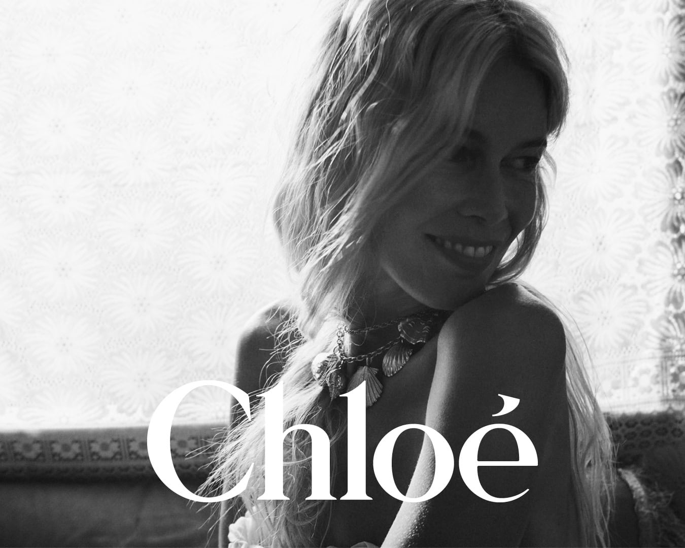 Monochrome portrait of model Claudia Schiffer wearing seashell necklace for Chloé High Summer campaign photographed by David Sims