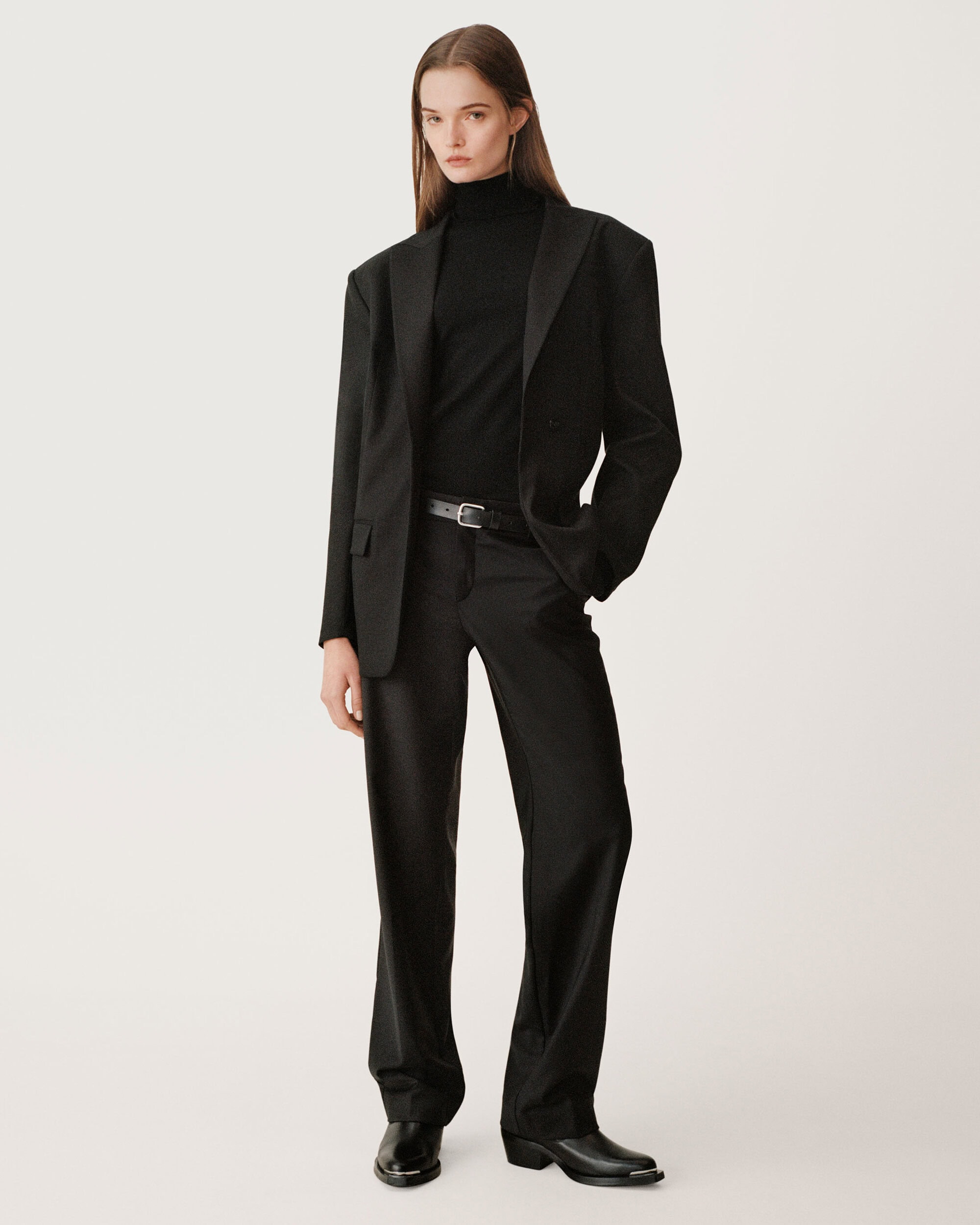 Model in black turtleneck, oversized blazer, and trousers standing against a seamless background for Zara