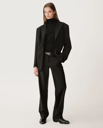 Model in black turtleneck, oversized blazer, and trousers standing against a seamless background for Zara