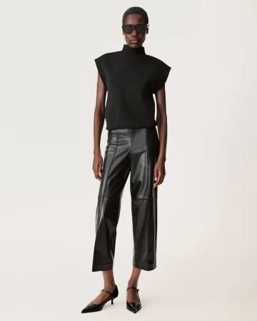 Model wearing a black sleeveless top, leather pants, and sunglasses against a seamless white background for Zara.