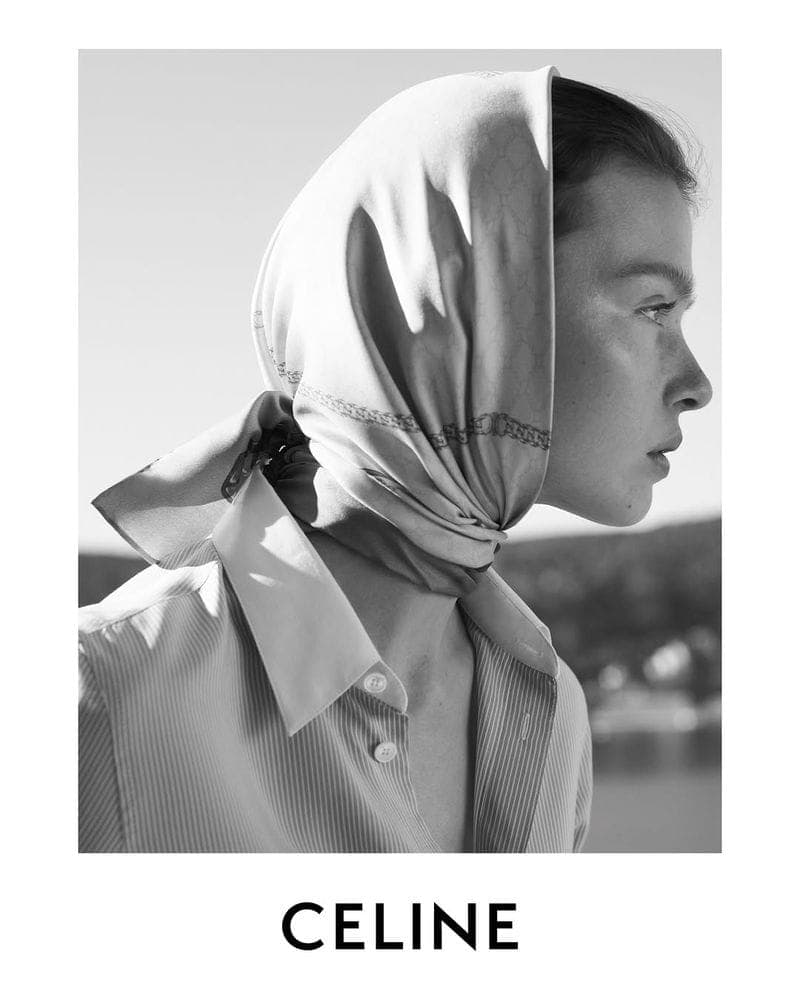 Black and white portrait of a model wearing a patterned headscarf and collared shirt for Celine.