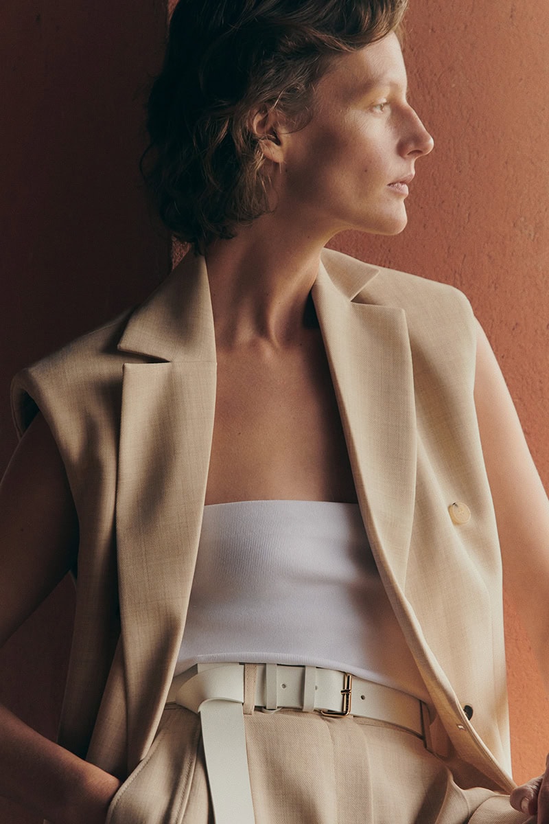 Model wearing a beige sleeveless vest and trousers against a warm terracotta background for the Giada spring campaign