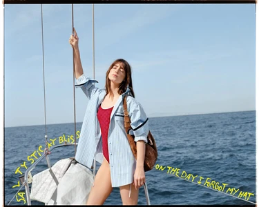 Daisy Edgar-Jones in a striped shirt and red swimsuit holding a boat rigging on the ocean for Gucci Lido Spring 2025 campaign.