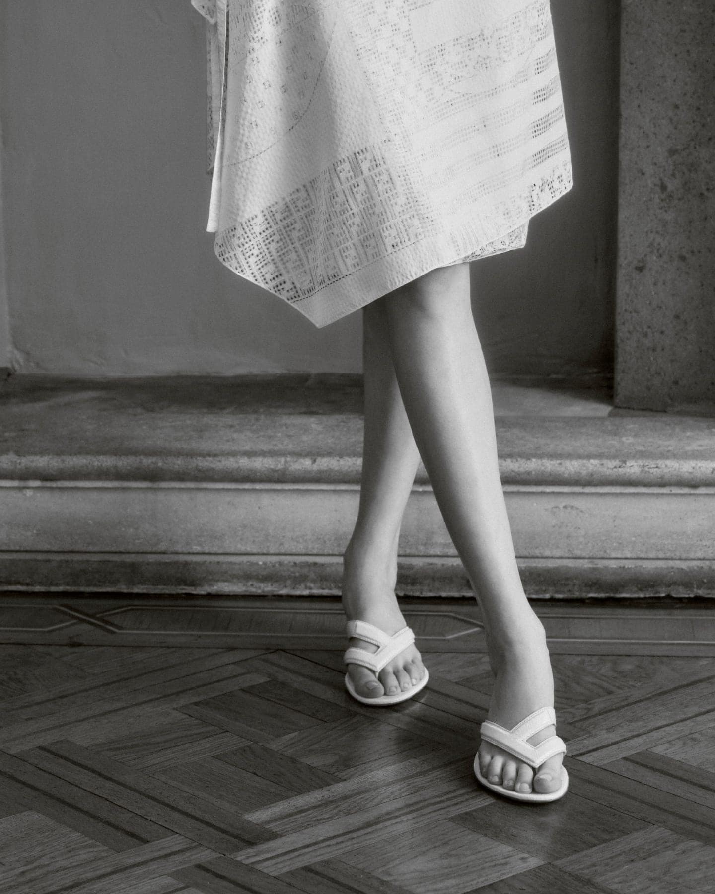 Close-up of model Achol Kuir wearing white sandals and a patterned skirt for Fendi Summer 2025 ad campaign.