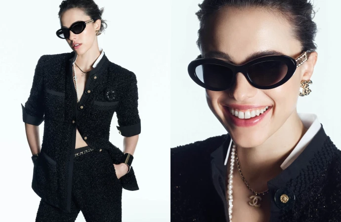 Model wearing dark oval sunglasses and a black tweed suit against a white seamless background for Chanel Eyewear Spring 2025 ad campaign.