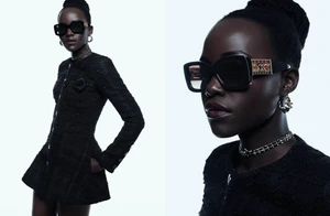 Lupita Nyongo wearing black sunglasses and a dark tweed jacket against a clean white background for Chanel Eyewear Spring 2025.