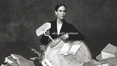 Model Sarah Paulson wearing a black blazer behind illustrative set props for Ami Spring 2025 campaign