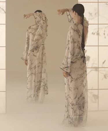 Model in printed sheer floral dress posing before a large mirror reflecting her back view, captured for Dior campaign.
