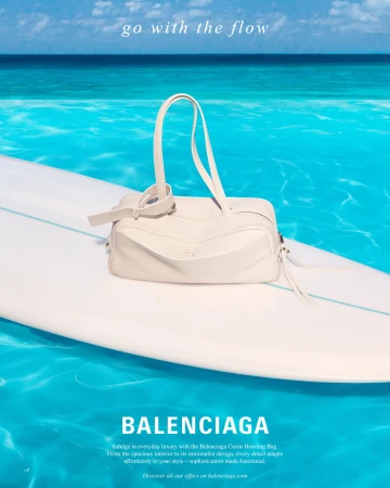 White handbag resting on a white surfboard floating over vibrant turquoise ocean water under a clear sky.