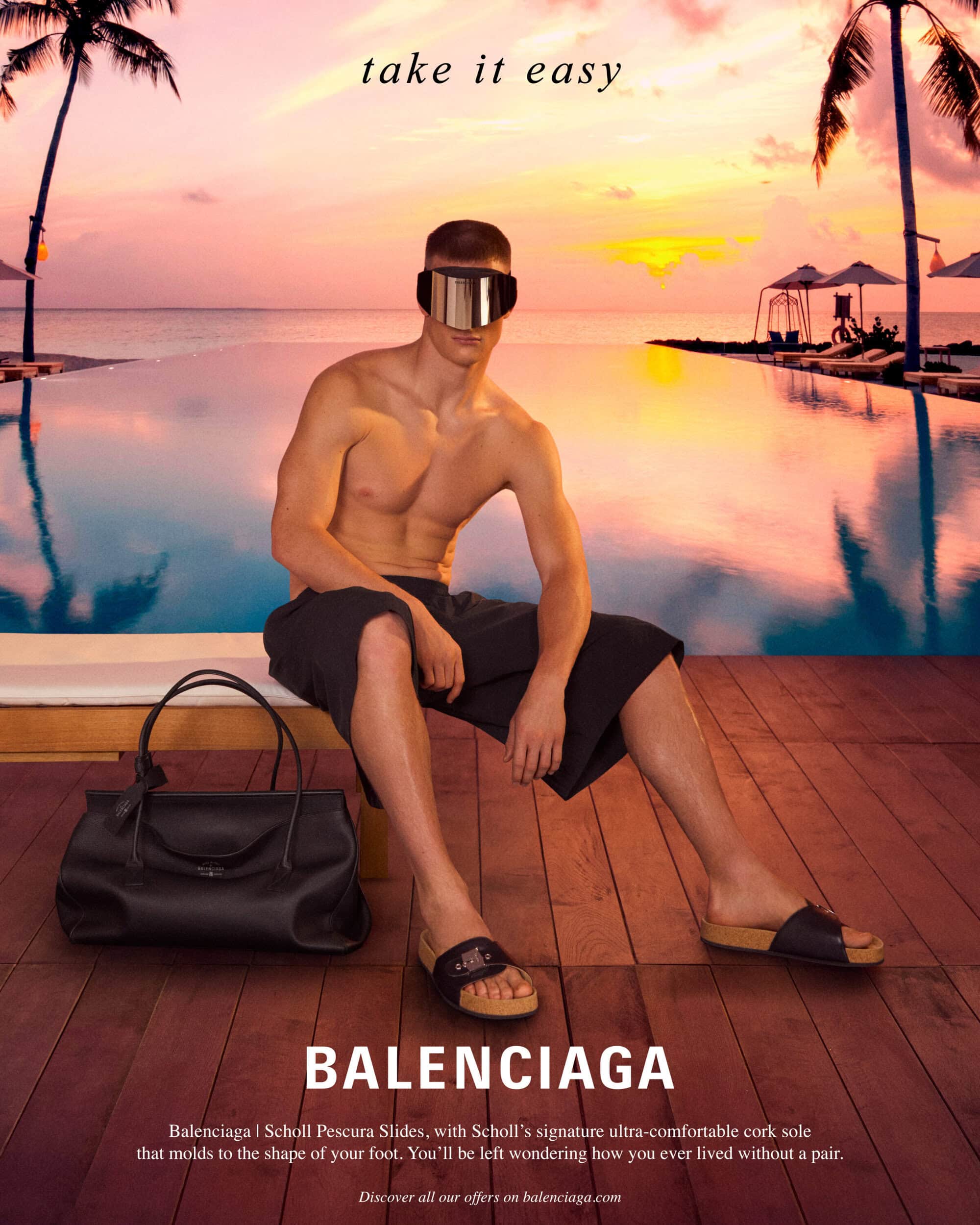 Shirtless man wearing mirrored visor sunglasses and dark shorts sitting by an infinity pool at sunset for Balenciaga