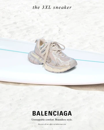 Balenciaga 3XL sneaker resting on a white surfboard set against a sandy beach background