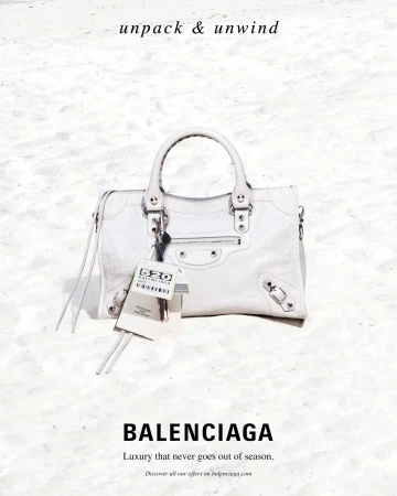 White Balenciaga leather handbag placed on a pale sandy beach for a high summer campaign image photographed by Roe Ethridge.