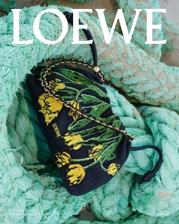 Black handbag with embroidered yellow flowers resting on large turquoise nautical rope for Loewe Paula's Ibiza campaign