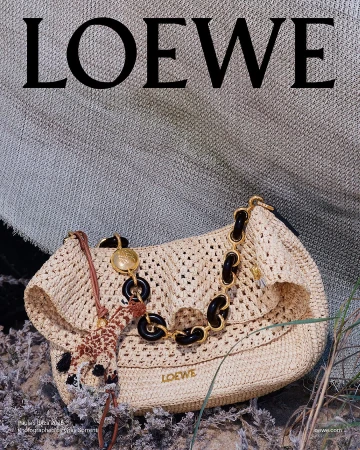 Loewe straw shoulder bag with chain strap and small giraffe charm resting on ground