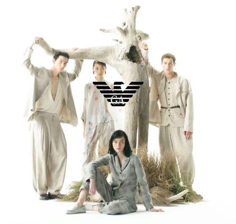 Group of four models posing around a large driftwood sculpture against a white background for Emporio Armani