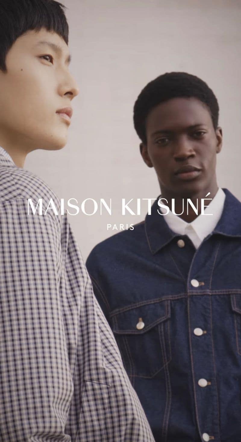 Two male models posing against a neutral backdrop for Maison Kitsune Spring 2025 campaign