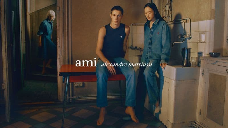 A man and woman posing in a rustic kitchen interior for an Ami Paris ad campaign, captured by photographer Daniel Archer.