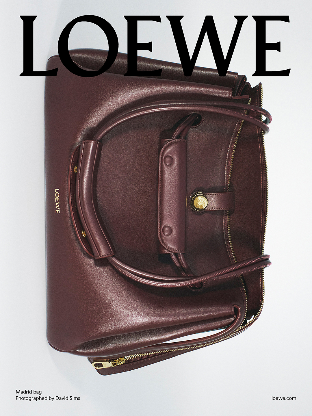Burgundy leather Loewe Madrid bag against a plain white background with bold black typography overhead.