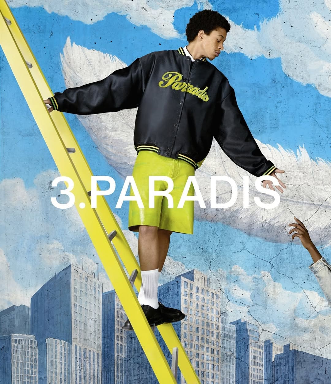 Model standing on a yellow ladder wearing a black lettered jacket and lime shorts against a blue sky background