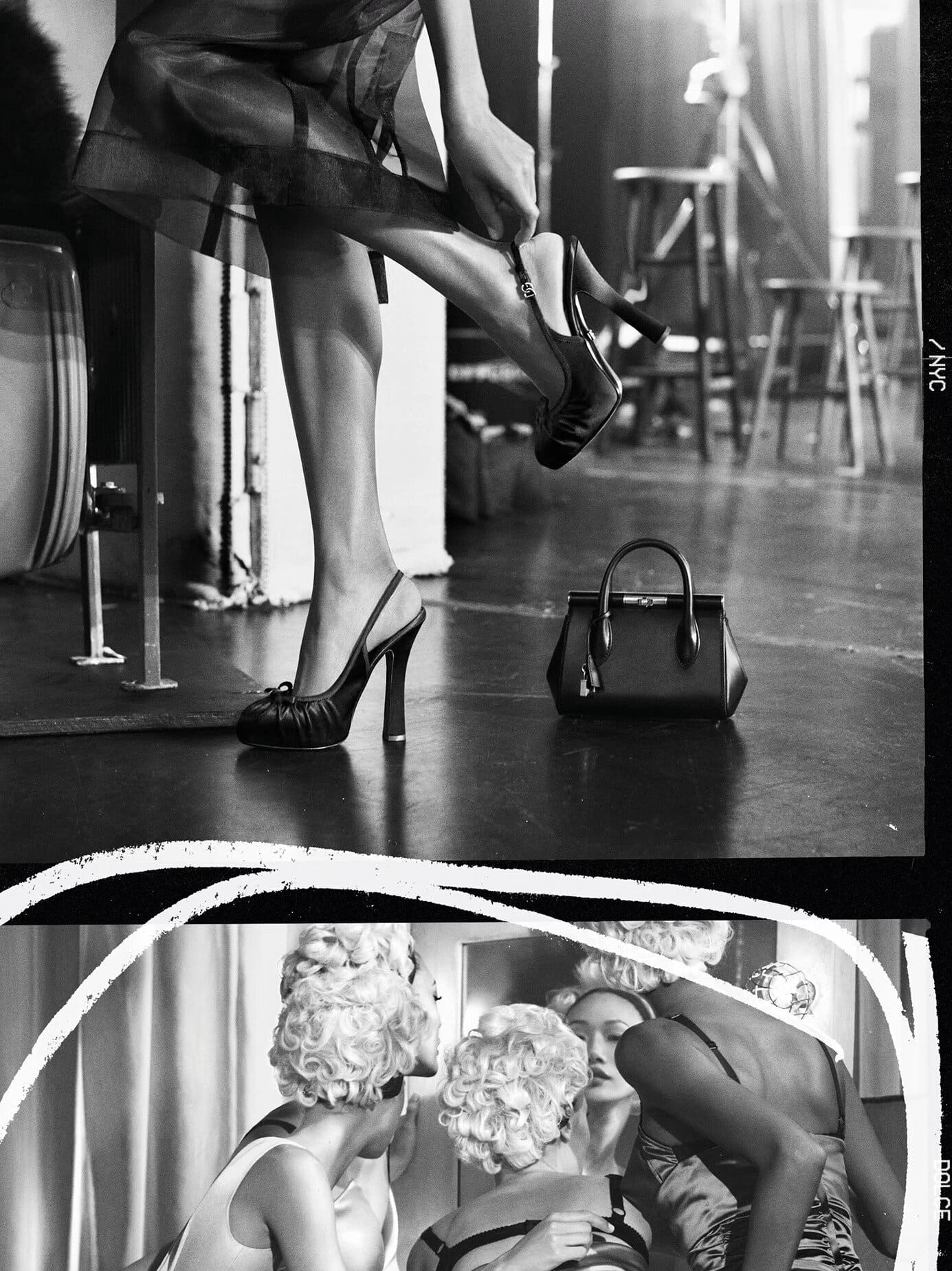 Black and white editorial image of a model putting on a high heel shoe with a handbag resting on the floor nearby