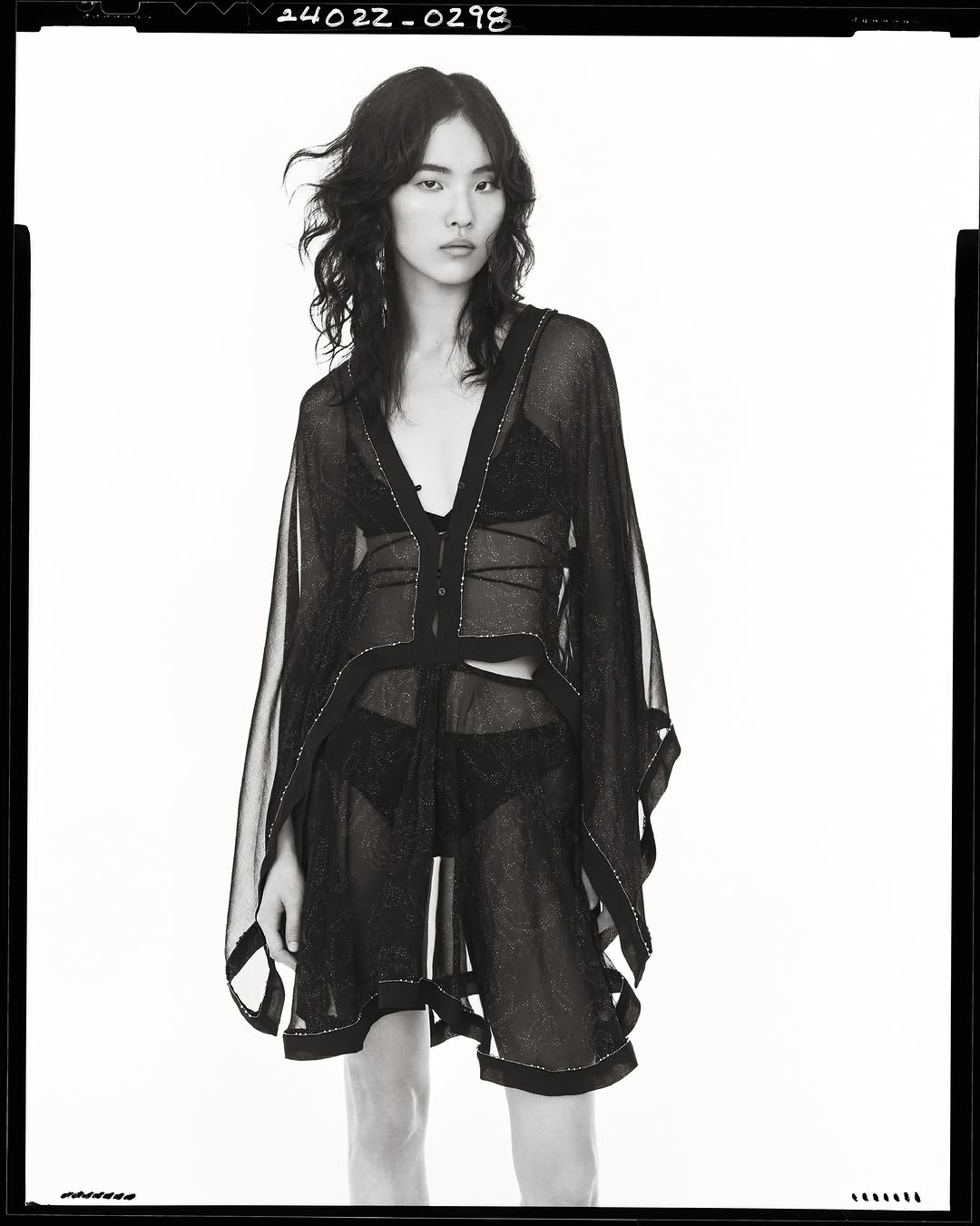 Model in sheer black overlay top and briefs against a seamless white background, photographed by Steven Meisel for Zara