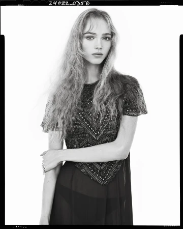 Model in embellished short-sleeve dress against a plain white studio background in a vertical monochrome fashion frame