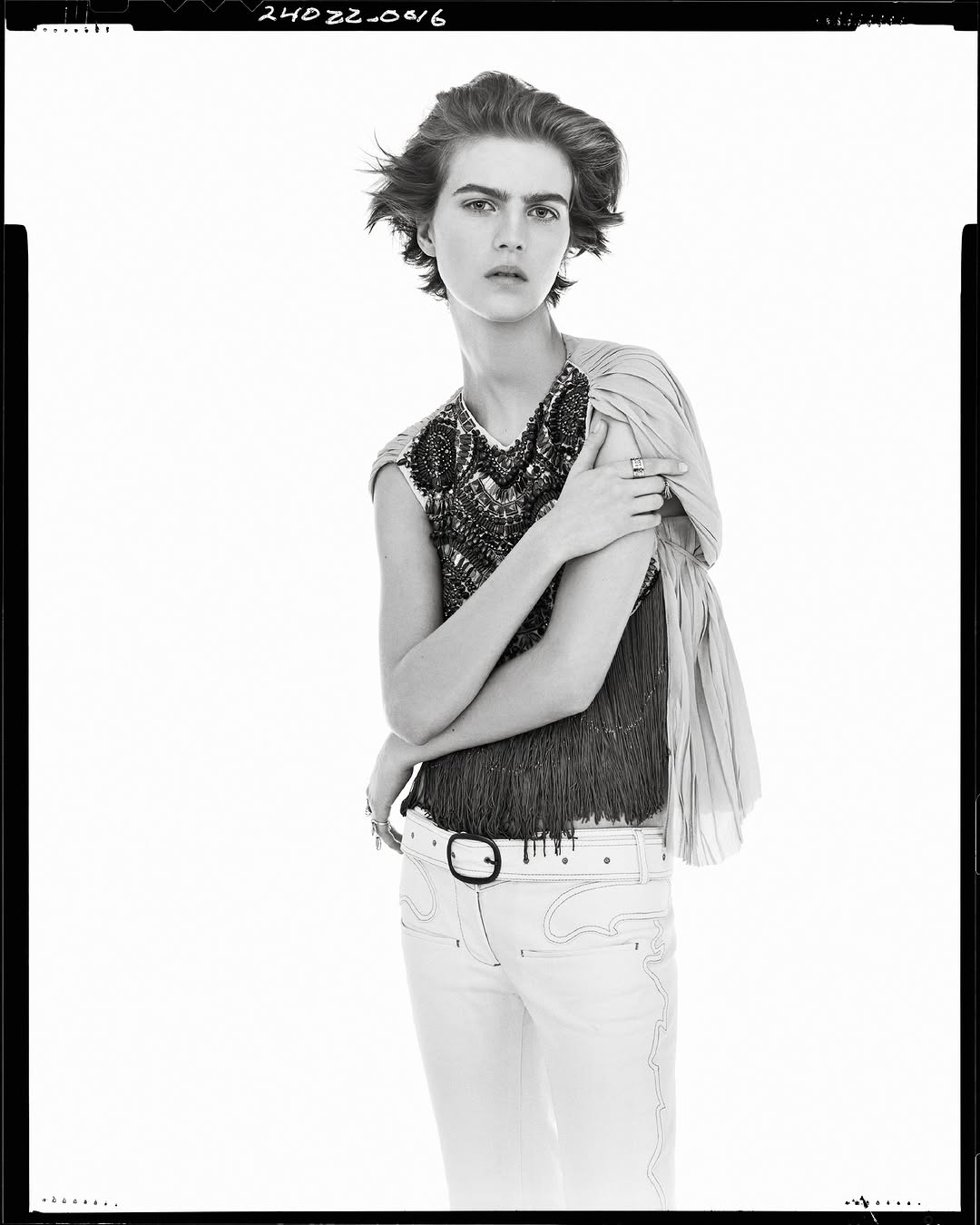 Monochrome portrait of a model in patterned top and light trousers against a plain white background for Zara.